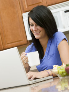 A beautiful woman on her computer while having breakfast